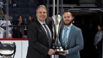 General Manager Kevin Cheveldayoff of the Winnipeg Jets presents Toby Enstrom #39 (R) with the Dan Snyder Memorial Trophy during the second intermission between the Jets and the Chicago Blackhawks at the Bell MTS Place on April 7, 2018 in Winnipeg, Manitoba, Canada. (Photo by Jonathan Kozub/NHLI via Getty Images)