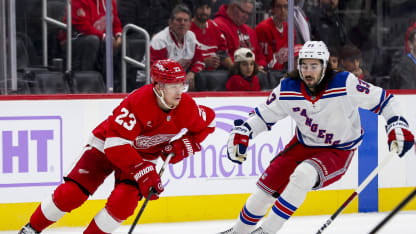 DETROIT, MICHIGAN - NOVEMBER 09: Lucas Raymond #23 of the Detroit Red Wings skates the puck up the ice against Mika Zibanejad #93 of the New York Rangers in the first period of a game at Little Caesars Arena on November 09, 2024 in Detroit, Michigan. (Photo by Mike Mulholland/Getty Images)
