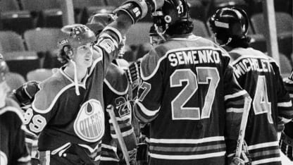 Canadian hockey players Wayne Gretzky, #99 for the Edmonton Oilers, and Dave Semenko (#27) celebrate a win with American teammate Joe Micheletti (#4) after a World Hockey Association (WHA) game against the New England Whalers, Springfield, Massachusetts, 1979. (Photo by Bruce Bennett Studios via Getty Images/Getty Images)