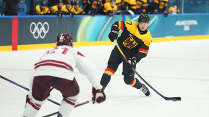 John Peterka #77 of Team Germany shoots the puck defended by Rudolfs Balcers #21 of Team Latvia in the third period during the Men's Preliminary Group C match between Germany and Latvia on day eight of the Milano Cortina 2026 Winter Olympic games at Milano Rho Ice Hockey Arena on February 14, 2026 in Milan, Italy. (Photo by Gregory Shamus/Getty Images)