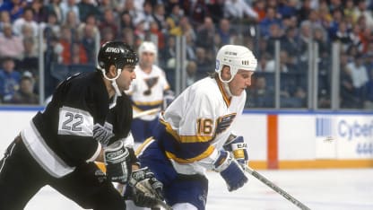 Brett Hull #16 of the St. Louis Blues skates with Charlie Huddy #22 of the Los Angeles Kings during an NHL Hockey game circa 1991 at the St. Louis Arena in St. Louis, Missouri. Hull's playing career went from 1986-2005. (Photo by Focus on Sport/Getty Images)