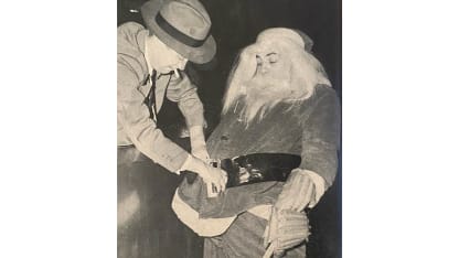 Rangers center Phil Watson getting dressed as Santa with help from team secretary Pat Doyle