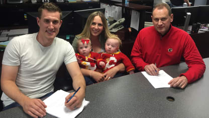 Michael Stone - along with his wife Michelle and their twins Jolie and Wyatt - put pen to paper on his new deal along with Flames GM Brad Treliving.