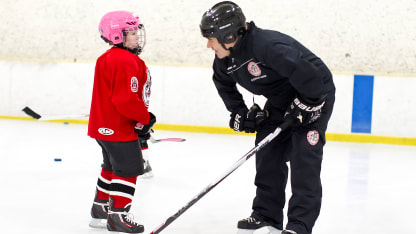 Barr_teaches_hockey_to_young_player