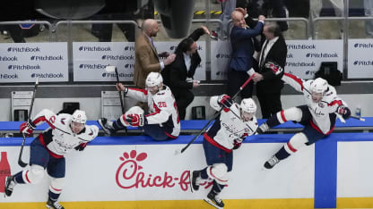 : Mitch Love, Scott Allen, Spencer Carbery, and Kirk Muller of the Washington Capitals celebrate as Brandon Duhaime #22, Nic Dowd #26, Anthony Beauvillier #72, and Ryan Leonard #9 of the Washington Capitals leap off the bench after Alex Ovechkin #8 scores his 895th career goal, passing Wayne Gretzky for the all-time scoring record, during the second period of a game against the New York Islanders at UBS Arena on April 6, 2025 in Elmont, New York. (Photo by Jess Rapfogel/NHLI via Getty Images)