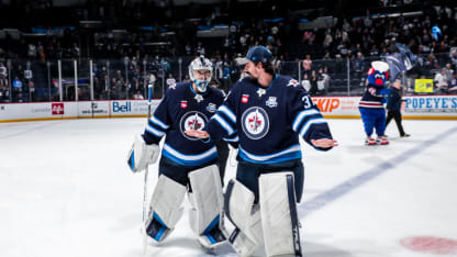 Goaltenders Eric Comrie #1 and Connor Hellebuyck #37 of the Winnipeg Jets leave the ice following a 5-2 victory over the Columbus Blue Jackets at the Canada Life Centre on November 18, 2025 in Winnipeg, Manitoba, Canada. (Photo by Darcy Finley/NHLI via Getty Images)