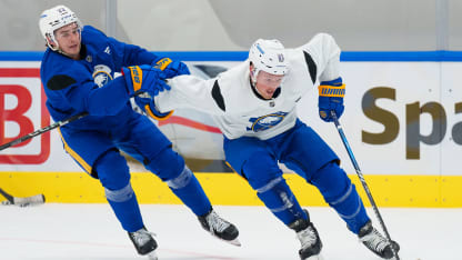 Sam Lafferty #81 of the Buffalo Sabres shields teammate Jack Quinn #22 of the Buffalo Sabres