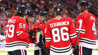 Connor Bedard #98 of the Chicago Blackhawks talks with Tyler Bertuzzi #59, Taylor Hall #71, Teuvo Teravainen #86 and Seth Jones #4