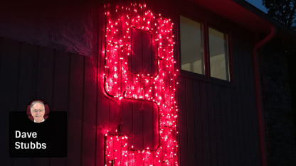 Gordie Howe's No. 9 lit up on the side of a house with Stubbs Badge