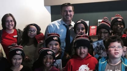 Photo of David Clarkson posing for a photo with a group of chilldren.