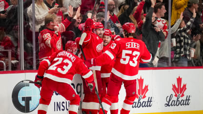Lucas Raymond #23, Dylan Larkin #71, Alex Debrincat #93 and Moritz Seider #53 of the Detroit Red Wings celebrate with Larkin after he scored a goal against the Dallas Stars during the third period at Little Caesars Arena on December 23, 2025 in Detroit, Michigan. (Photo by Nic Antaya/Getty Images)