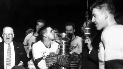Ted Lindsay #7 of the Detroit Red Wings kisses the cup as manager Jack Adams and the rest of the Wings celebrate winning the Stanley Cup after beating the Montreal Canadiens in Game 7 of the Stanley Cup Playoffs on April 16, 1954 at Olympia Stadium in Detroit, Michigan. The Red Wings defeated the Canadiens 2-1 in overtime. (Photo by Bruce Bennett Studios via Getty Images Studios/Getty Images)