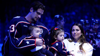 Sean Monahan #23 of the Columbus Blue Jackets stands on the ice while holding former Columbus Blue Jackets player Johnny Gaudreaus son, Johnny Jr, along side Gaudreaus wife and daughter, Meredith and Noah, during a remembrance ceremony prior to the start of the game against the Florida Panthers at Nationwide Arena on October 15, 2024 in Columbus, Ohio. Gaudreau and his brother Matthew were killed when hit by a suspected drunk driver on August 29, 2024.(Photo by Kirk Irwin/NHLI via Getty Images)