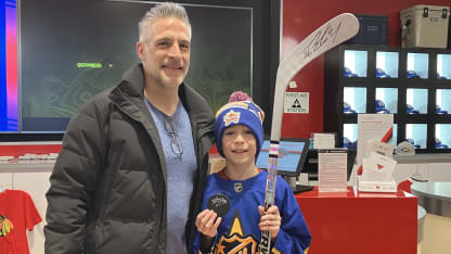 Bedard event siging kid posing with signed stick and puck