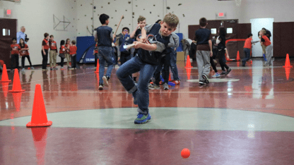 Photo of a young boy shooting a ball with a hockey stick during a Blue Jackets Power Play Challenge event.