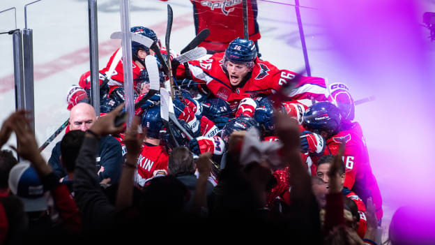 Nic Dowd jumps onto team huddle as the Washington Capitals celebrate overtime game winning goal by Alex Ovechkin at Game One of the First Round of the 2025 Stanley Cup Playoffs versus the Montreal Canadiens at Capital One Arena on April 21, 2025 in Washington, DC.