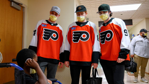 Nick Seeler, Jamie Drysdale, and Cam York visit with a patient at St. Christopher's Hospital for Children