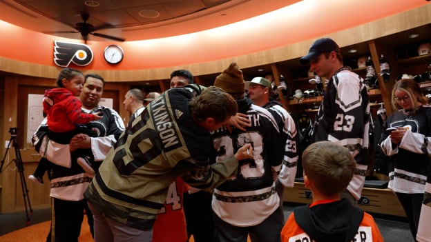 Cam Atkinson signs autographs for service members in the Flyers locker room