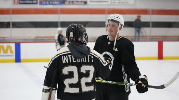 Nick Seeler skates with military member during the team’s annual military skate with the USO