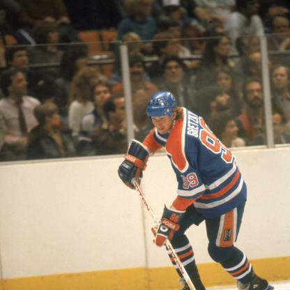 Canadian professional ice hockey player Wayne Gretzky #99 of the Edmonton Oilers skates on the ice with the puck during an away game, early 1980s. Gretzky played for the Oilers from 1978 to 1988. (Photo by Bruce Bennett Studios via Getty Images Studios/Getty Images)