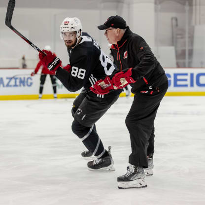 Assistant coach Ryan McGill works with defenseman Kevin Bahl at practice
