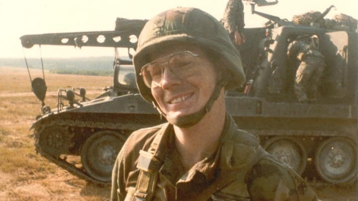 Photo of Blue Jackets military honoree, Rodney Howdyshell, posing for the camera in his army uniform in front of a tank.