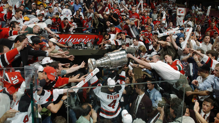 Scott Stevens of the New Jersey Devils carries the Stanley Cup holds up the Stanley Cup