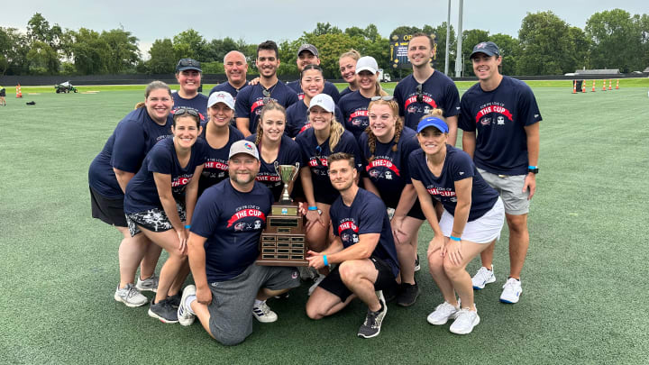 Photo of Blue Jackets staff posing with the Community Cup trophy.
