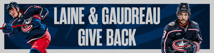 Blue header with grey border. Large grey text at center reads Laine & Gaudreau Give Back. Photo of Patrik Laine in Blue Jackets home jersey to the left and photo of Johnny Gaudreau in Blue Jackets home jersey to the right.