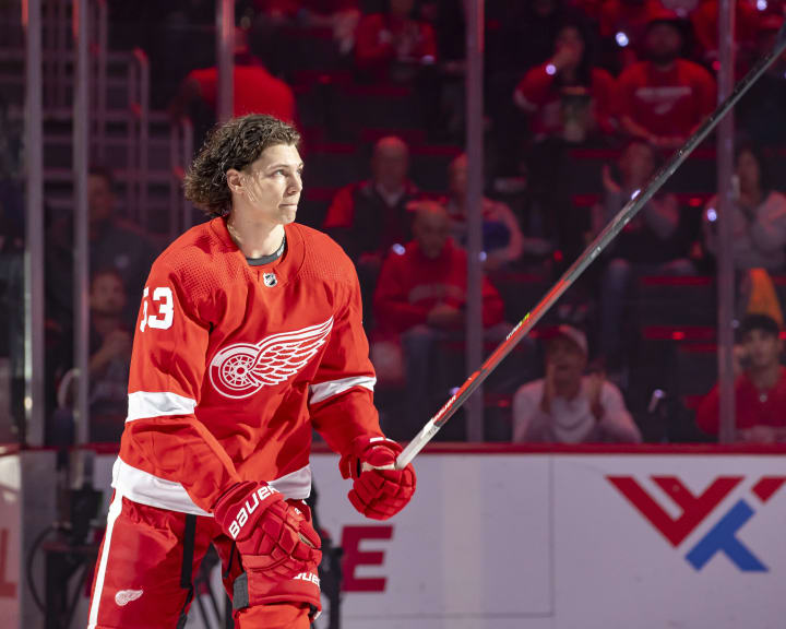 Moritz Seider #53 of the Detroit Red Wings skates out during opening night ceremonies before NHL game against the Tampa Bay Lightning at Little Caesars Arena on October 14, 2021 in Detroit, Michigan. Tampa defeated Detroit in O.T. 7-6.(Photo by Dave Reginek/NHLI via Getty Images)