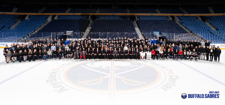 Photo of 2022-2023 Buffalo Sabres players and staff at center ice
