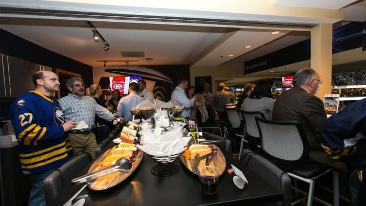 Photo from inside one of key bank center's party suites showing fans watching the game and browsing the selection of food and drinks