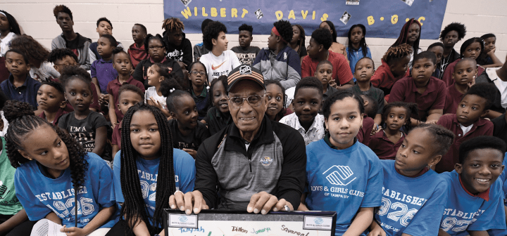 Willie O'Ree poses with young kids.