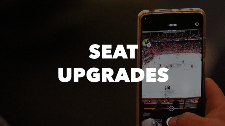 Photo of a phone taking a picture of the ice at an Ottawa Senators game at the Canadian Tire Centre with the words "Seat Upgrades" in white letters.