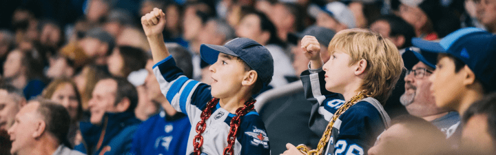 Young Jets fans cheering on the team during a game.