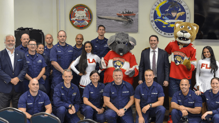 Active Coast Guard members with Panthers mascots, dance team, CEO, and Amerant Bank CEO