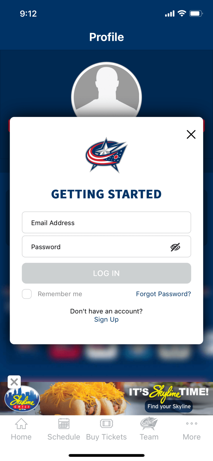 Screenshot of Blue Jackets App confirm profile screen. White overlay with blue text at the top reading Getting Started. Boxes below allow users to enter email address and password. Greyed out button reading Login is below the form fields. Checkbox below reads Remember me. Small blue text below reads Forgot Password? Small black text below reads Don't have an account? and Sign up.
